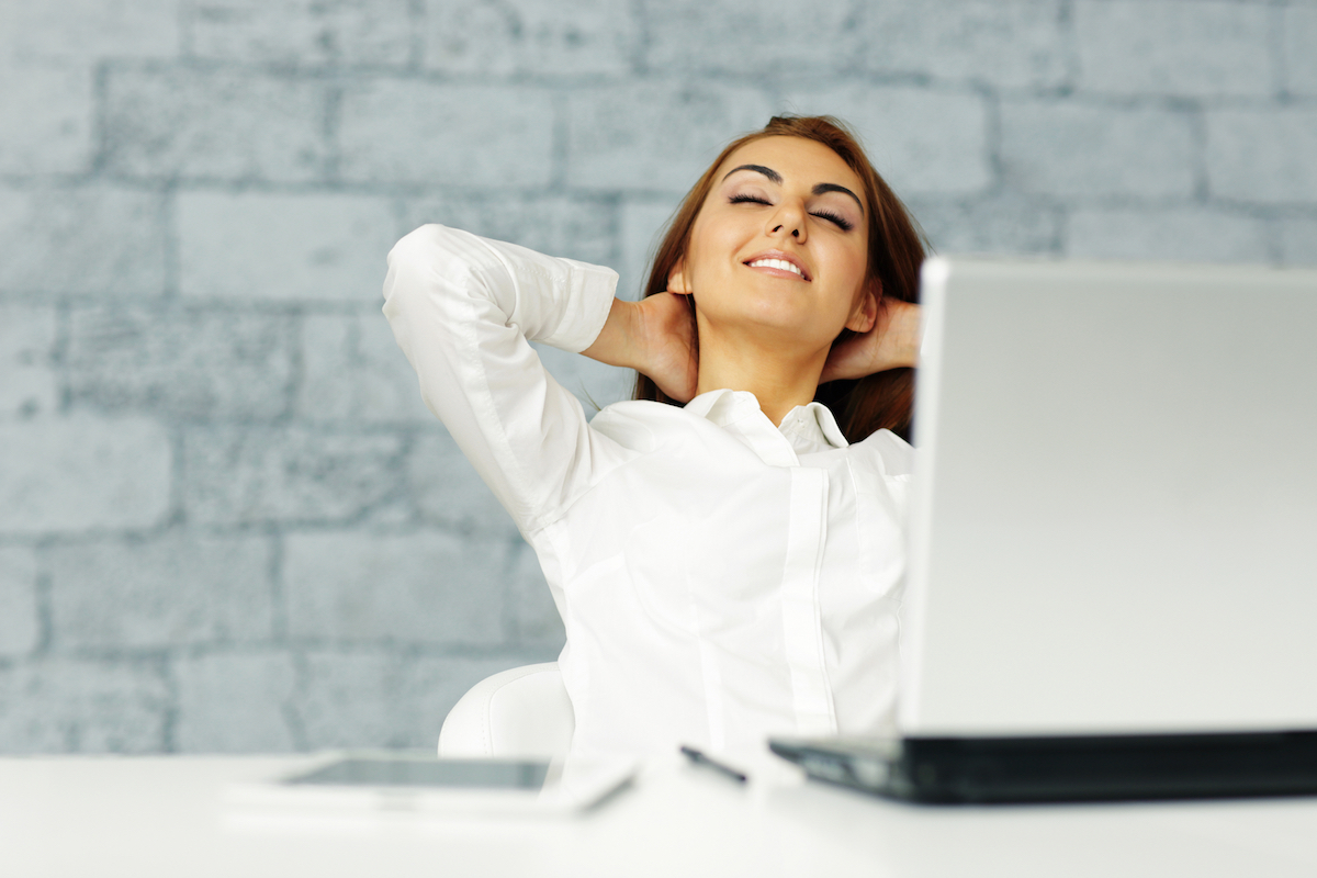 Young happy businesswoman stretching in front of her workplace
